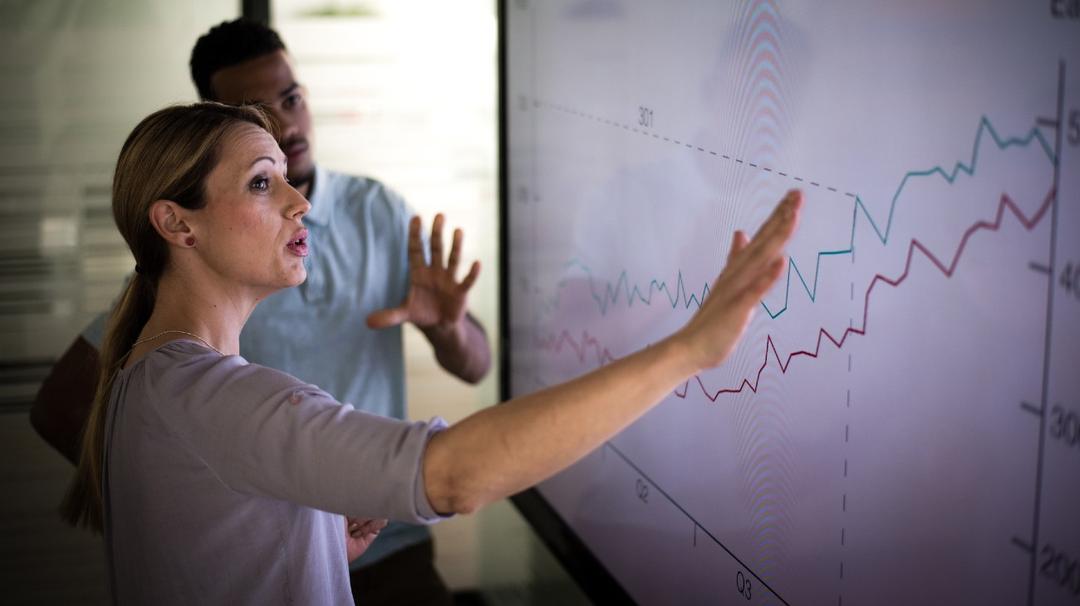 Businesswoman explaining graph to his coworker in conference room.