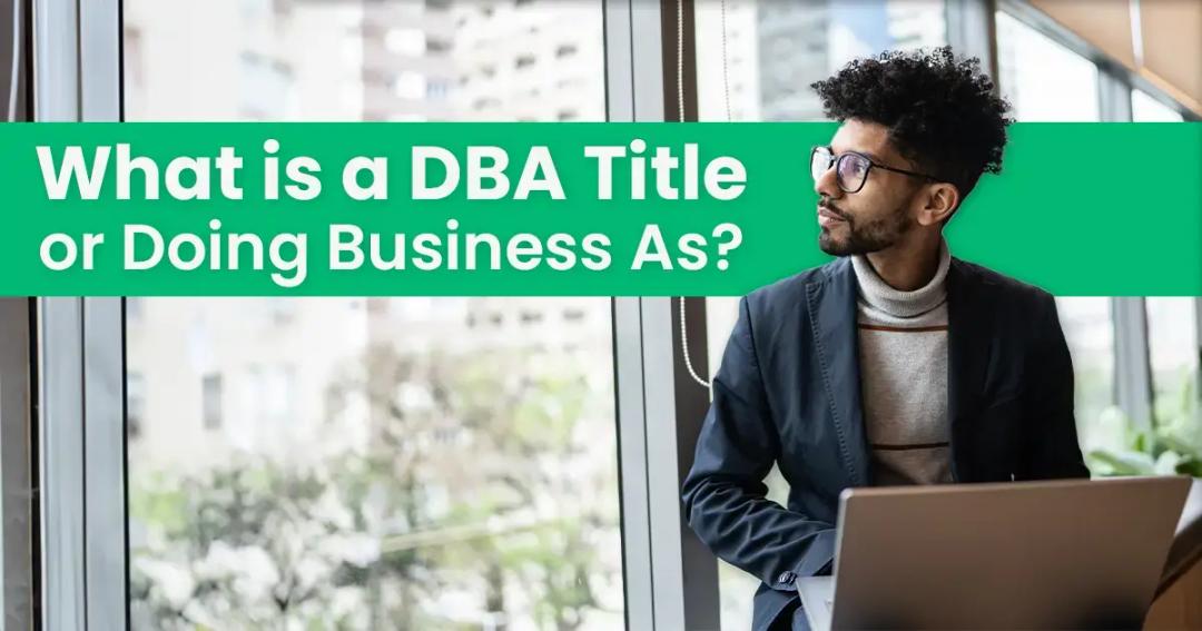 A man with curly hair sits at a laptop near a window, looking thoughtful. text above reads "what is a dba title or doing business as?.